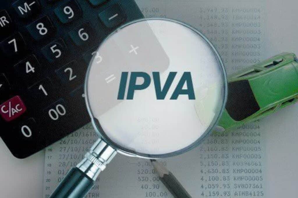Lupa destacando sigla IPVA sobre calculadora e papel.