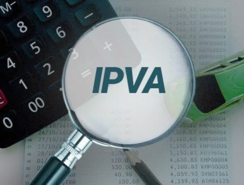 Lupa destacando sigla IPVA sobre calculadora e papel.